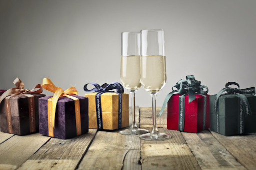 Two champagne flutes surrounded by gifts