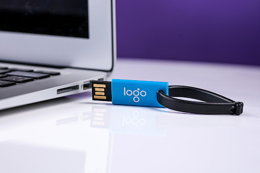 A USB drive promotional product with a logo placeholder.